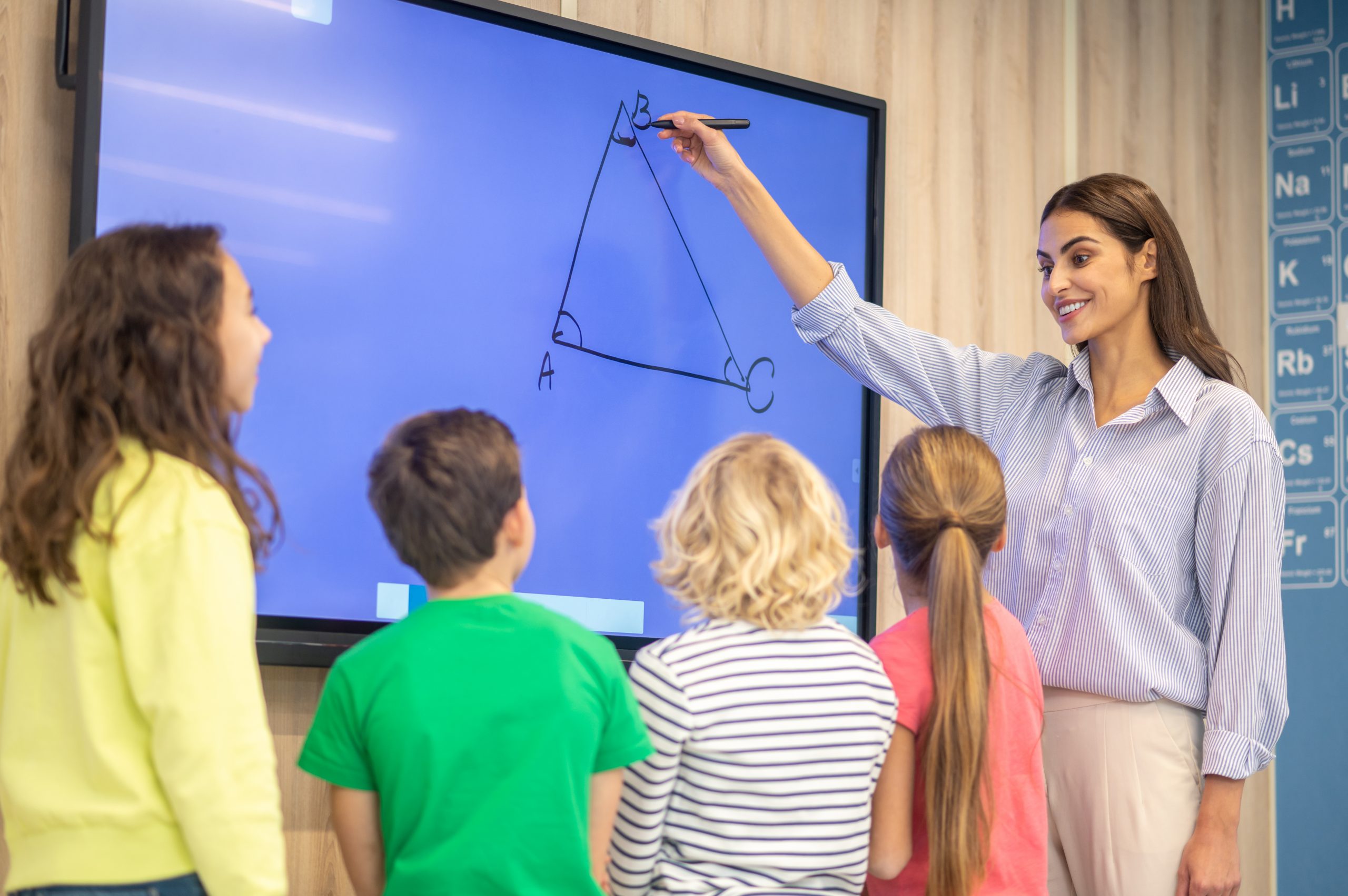 Woman drawing showing triangle on blackboard to children Paperboard digital